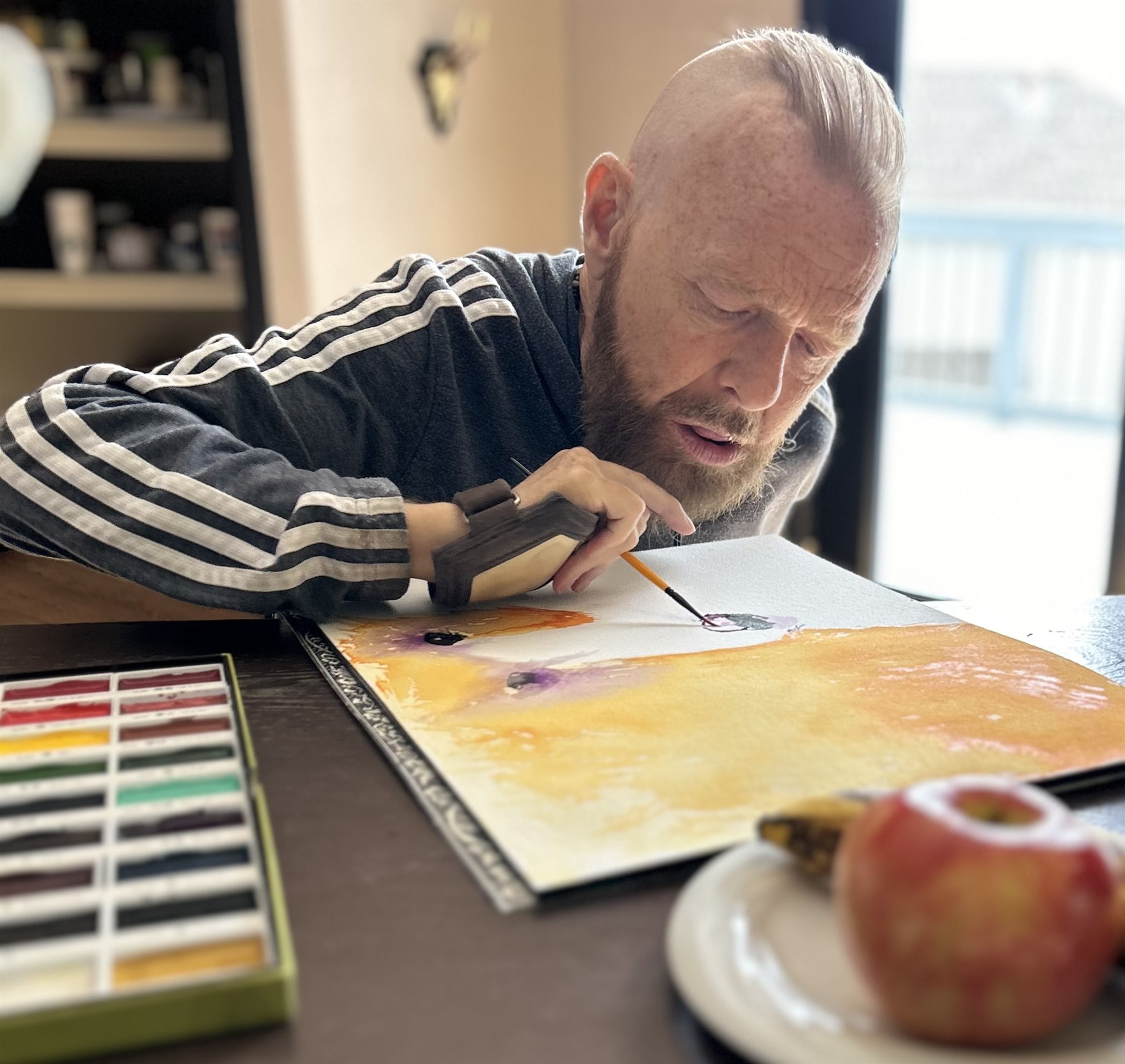 Matt Hendrick painting with a brush held in his mouth